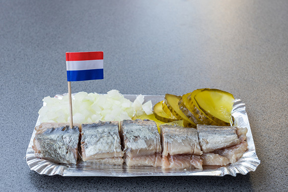 Aluminium bord met haring, uitjes, augurk en een Nederlands vlaggetje