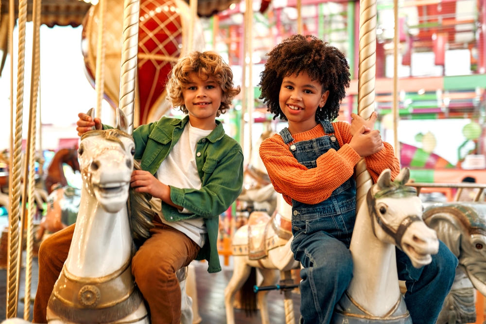 Kinderen op paardje in carrousel pretpark