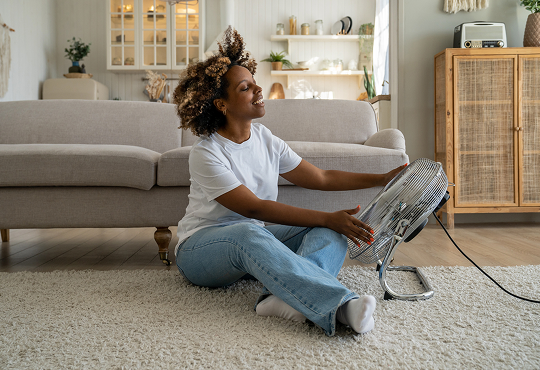 Vrouw met ventilator in woonkamer